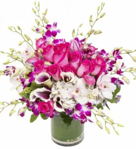pink roses and purple orchids with white flowers in vase