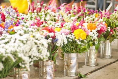 Colorful flowers in recycled tin cans
